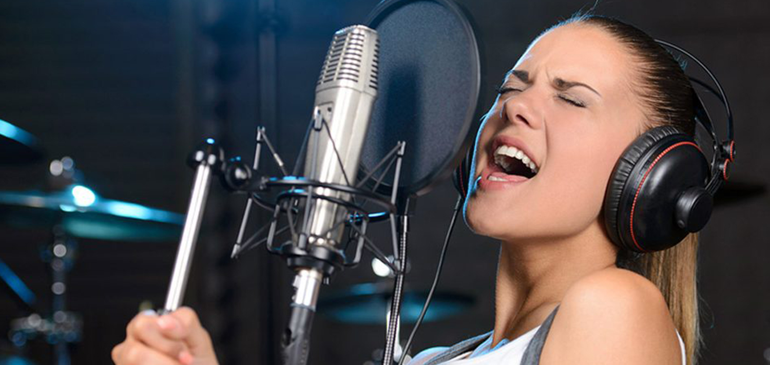 Веселые вокальные песни. Девушка с микрофоном. Поет в студии. Студия вокала. Девушка с микрофоном в студии.