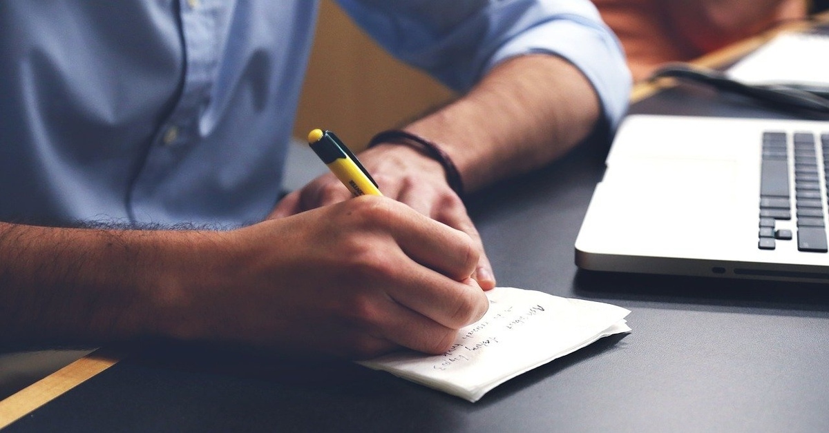 Писать. Человек записывает в блокнот. Мужчина за письменным столом. Человек за компьютером. Человек пишет текст.