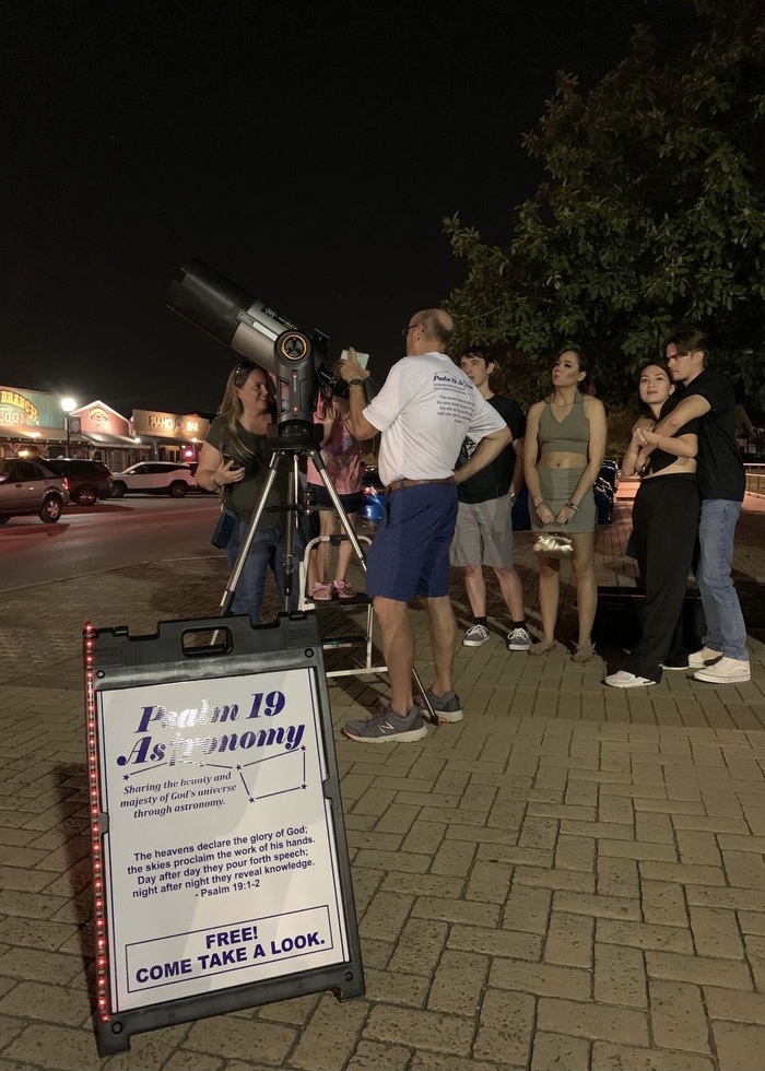 Представитель церкви предлагает всем желающим посмотреть в телескоп