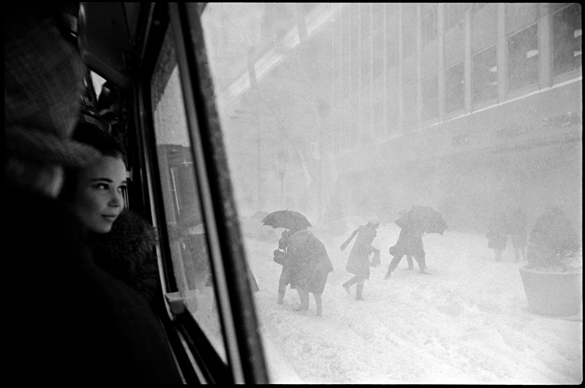 A girl on a bus and people on the street during a snowstorm, 1967, New York - The photo, New York, Blizzard, Magnum Photos