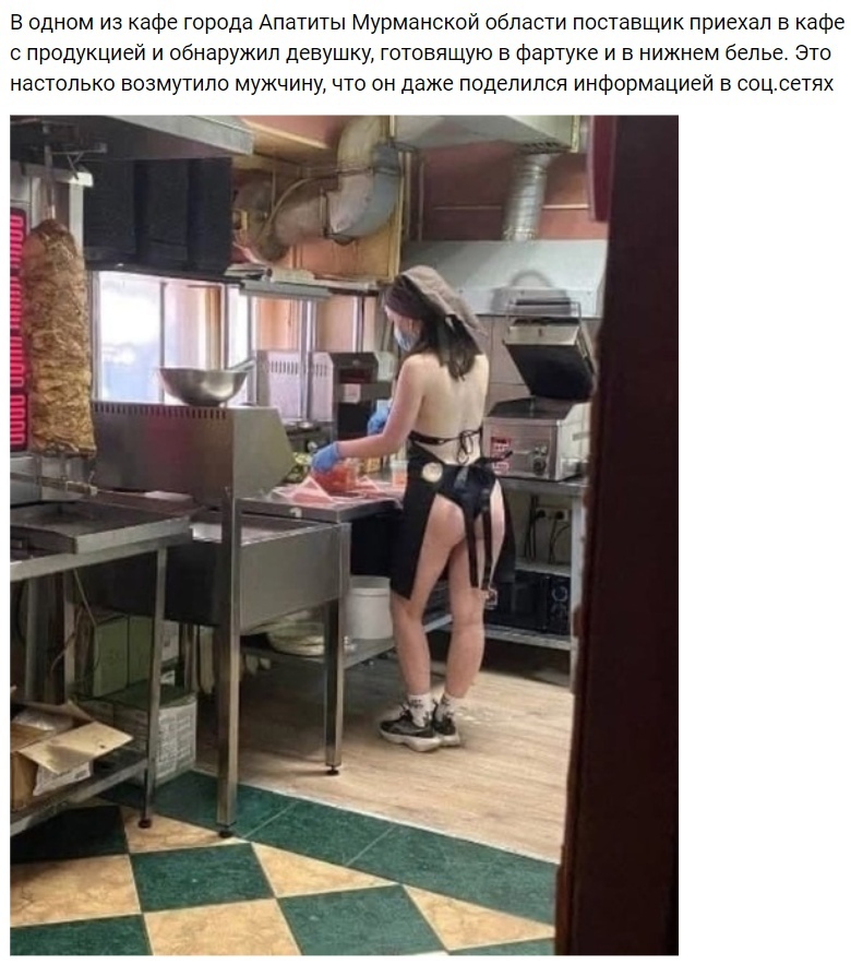 Голая девушка в фартуке на кухне во время готовки еды